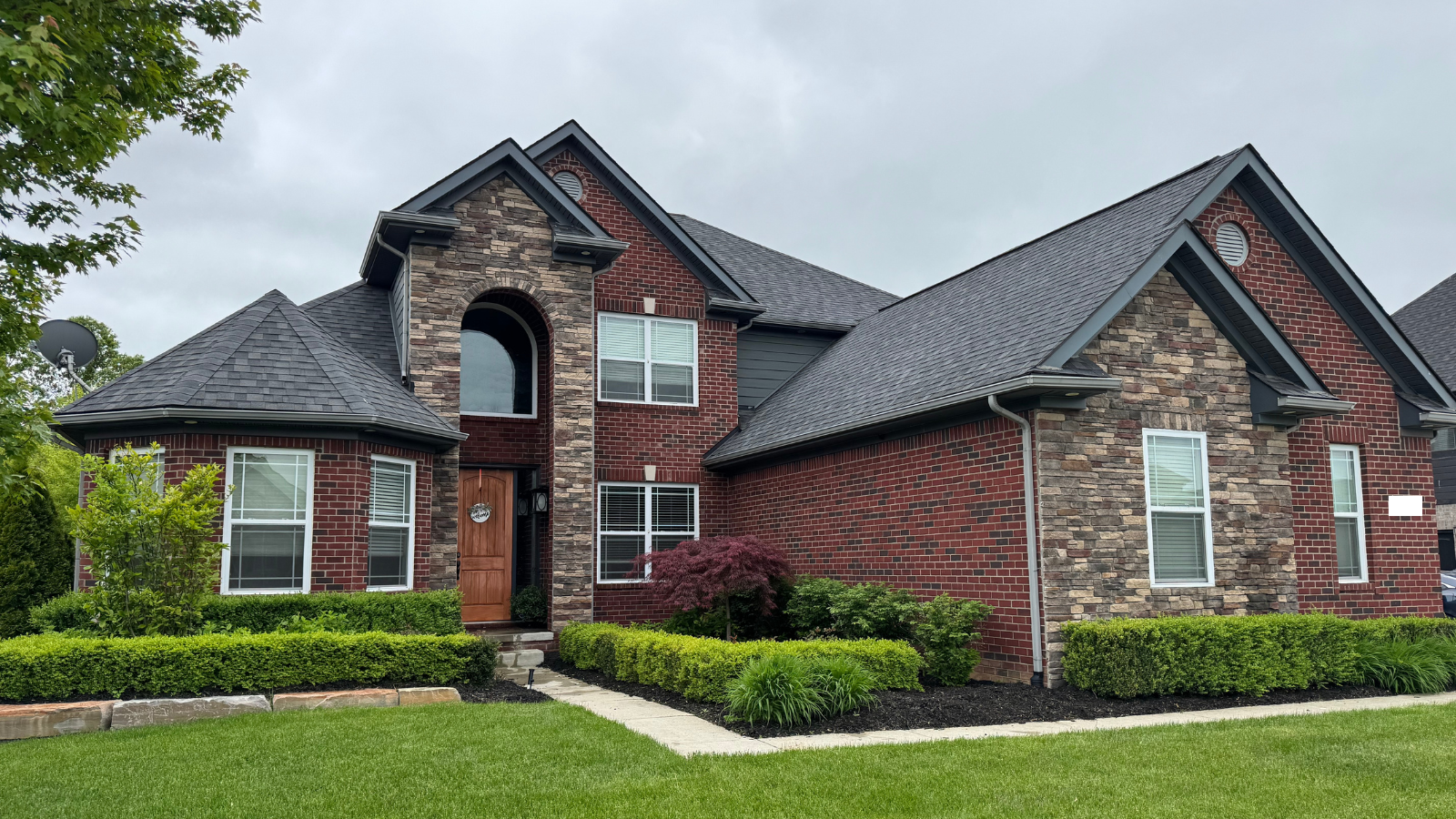Legacy Cleaning washing windows on a two-story colonial home in Macomb County, MI